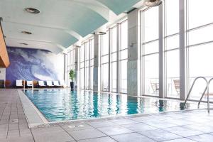 特拉维夫Luxury apartment with a great view的一座大型游泳池,位于一座带窗户的建筑内