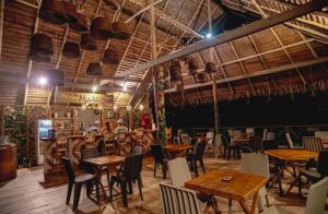 莱蒂西亚Biohotel Arara River的一间在房间内配有桌椅的餐厅