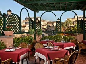 罗马阿尔伯格奥托森托酒店的庭院里的餐厅,配有红色的桌椅