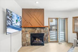 帕克城Luxe Deer Valley Condo的客厅设有壁炉和电视。