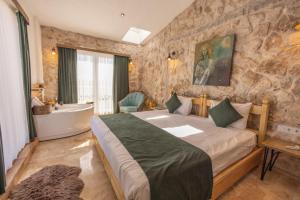 乌奇希萨尔Soleado Cappadocia Hotel的一间卧室设有一张大床和一个浴缸