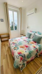 滨海自由城Hôtel La Villa Patricia - Charme et Tradition的一间卧室配有一张带五颜六色棉被的床