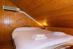杜布罗夫尼克克齐亚公寓的木制房间的一个床位,上面有毛巾