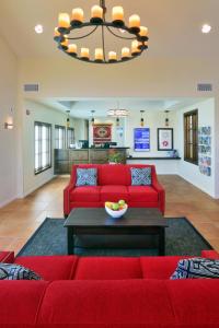 圣地亚哥Lamplighter Inn & Suites at SDSU的客厅配有红色的沙发和桌子