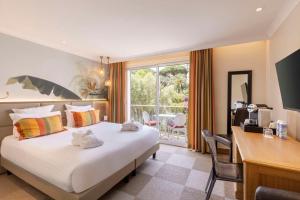 圣马克西姆Best Western Premier Montfleuri的配有一张床、一张书桌和一扇窗户的酒店客房