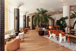 洛杉矶Santa Monica Proper Hotel, a Member of Design Hotels的大堂配有桌椅,大堂树木繁茂。