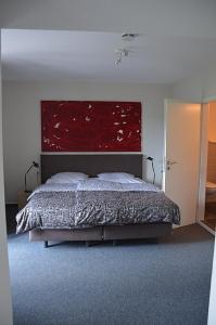 汉恩明登Hotel Schlafschön的一间卧室配有一张带红色大床头板的床