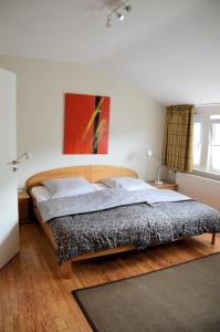 汉恩明登Hotel Schlafschön的卧室配有一张床,墙上挂有绘画作品