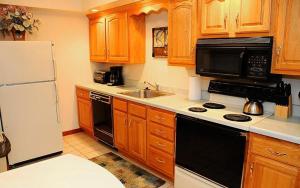 ChampionSeven Springs Deluxe Condo near Pool的厨房配有木制橱柜和白色冰箱。