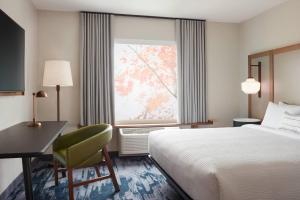莱思罗普Fairfield by Marriott Inn & Suites Stockton Lathrop的配有一张床、一张书桌和一扇窗户的酒店客房