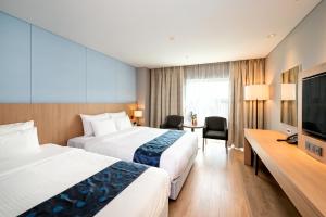 城南市Wirye Militopia Hotel的酒店客房设有两张床和一台平面电视。