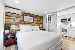 基韦斯特Julia Whitehead Guest Suites的卧室配有白色的床和砖墙