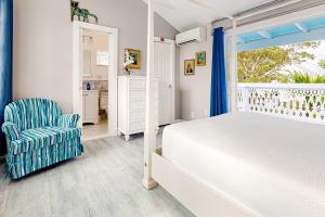 基韦斯特Julia Whitehead Guest Suites的卧室配有床、椅子和窗户。