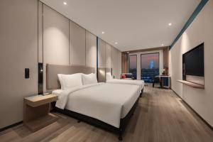 上海上海浦江智选假日酒店的酒店客房设有一张大床和一台电视。