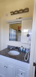 法尔茅斯Sehfeh Luxury vacation home的浴室的柜台设有水槽和镜子