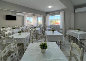 弗洛里亚诺波利斯Ilha Forte Praia Hotel的用餐室配有白色的桌子和白色的椅子