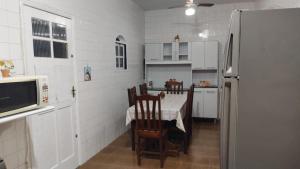 大伊瓜巴A Casa para a sua Família em Iguaba Grande, até 9 pessoas的厨房配有桌椅和冰箱。
