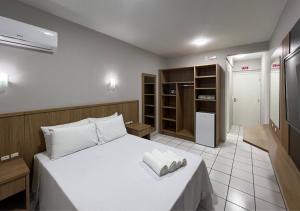 弗洛里亚诺波利斯Ilha Forte Praia Hotel的一间卧室配有带毛巾的床