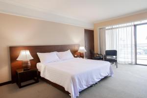 曼谷皇家河畔酒店的酒店客房设有一张床和一个大窗户