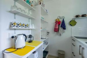 拉罗汤加Ann's Island Beach Studio的厨房在黄色的柜台上配有茶壶