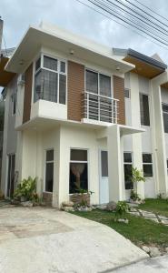 卡加盐德奥罗New 2 Bedroom Home的白色和棕色的房子设有阳台
