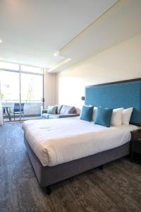 麦夸里港麦夸里港中心美居酒店的一间卧室配有一张大床和蓝色床头板
