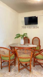 伊斯塔帕Casa ALOA Ixtapa的餐桌、椅子和花瓶