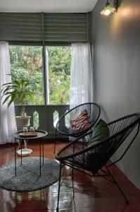 清迈Inn Oon Villa的一间设有两把椅子、一张桌子和一个窗户的房间