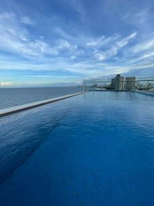 岘港De Lamour Hotel的一座背景海洋的游泳池