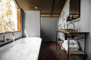 Woollamia佩博巴克露营酒店的带浴缸、水槽和镜子的浴室