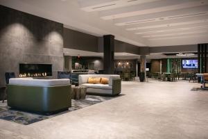 西得梅因West Des Moines Marriott的大堂设有壁炉、沙发和桌子。