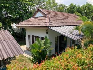 罗勇Vacation House with tropical garden and private pool的白色的小房子,设有瓷砖屋顶