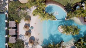 勒吉安巴厘曼迪拉海滩Spa度假酒店的享有棕榈树度假村游泳池的顶部景致