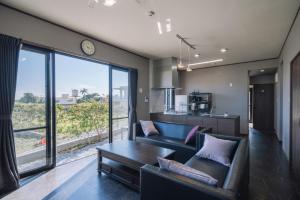 Hanagusukuプライベートハウス ぅーじ家的客厅配有沙发和桌子