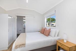 巴利纳Reflections Ballina - Holiday Park的白色的卧室设有一张大床和一个窗户
