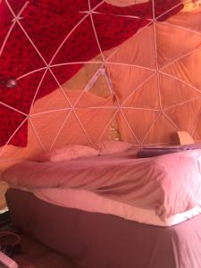 斯希丹Vintage Dome Igloo tent, Lange Haven Schiedam的一张位于帐篷内的床位,帐篷拥有红色和白色的墙壁