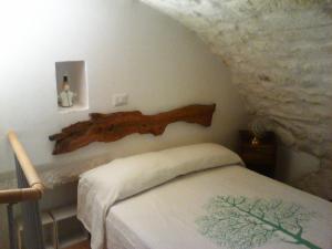 奥斯图尼Il Nido Bianco的卧室配有一张挂在墙上的木床