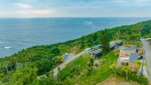 宫崎OceansideRanch Miyazaki的大海旁山丘上房屋的空中景观