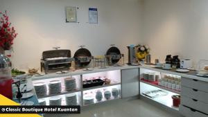 关丹Classic Boutique Hotel Kuantan的厨房配有带餐具的吧台