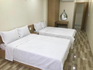 吉婆岛Sea Balcony Hotel的配有白色床单的酒店客房内的两张床