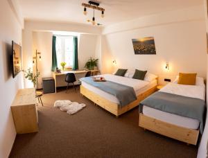 尼萨河畔亚布洛内茨雷哈维特尔酒店的酒店客房配有两张床、一张书桌和一张书桌。