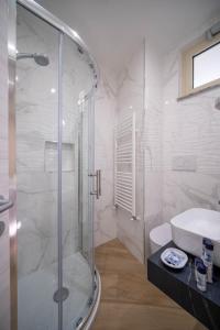 奥利韦里ESPERIA B&B的一间带玻璃淋浴和水槽的浴室