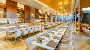 西哈努克Won Majestic Hotel Cambodia的用餐室配有白色的桌子和白色的椅子