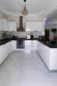 塔格梅斯Villa Line的厨房配有白色橱柜和白色瓷砖地板。