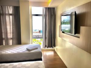斯里曼绒双喜酒店的一间卧室配有一张床和一台平面电视