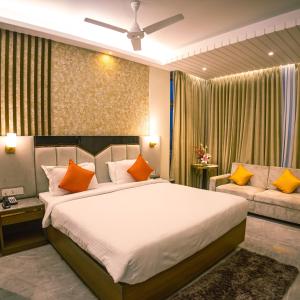 加尔各答Brio Hotel的一间卧室配有一张大床和一张沙发
