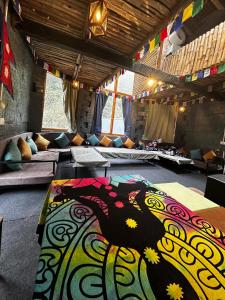 ShojaSunshine Cafe & Cottage Riverside的一间配有沙发的房间,地板上铺有色彩缤纷的地毯