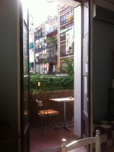 巴塞罗那SANT ANTONI HOSTAL, Sustainable Tourism的阳台配有桌椅,公寓大楼