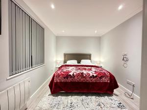 伦敦Stylish Central London Apartment的一间卧室配有一张红色床罩的床