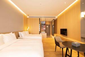 鹿港镇鹿港澄悅酒店的酒店客房设有两张床和一张桌子。